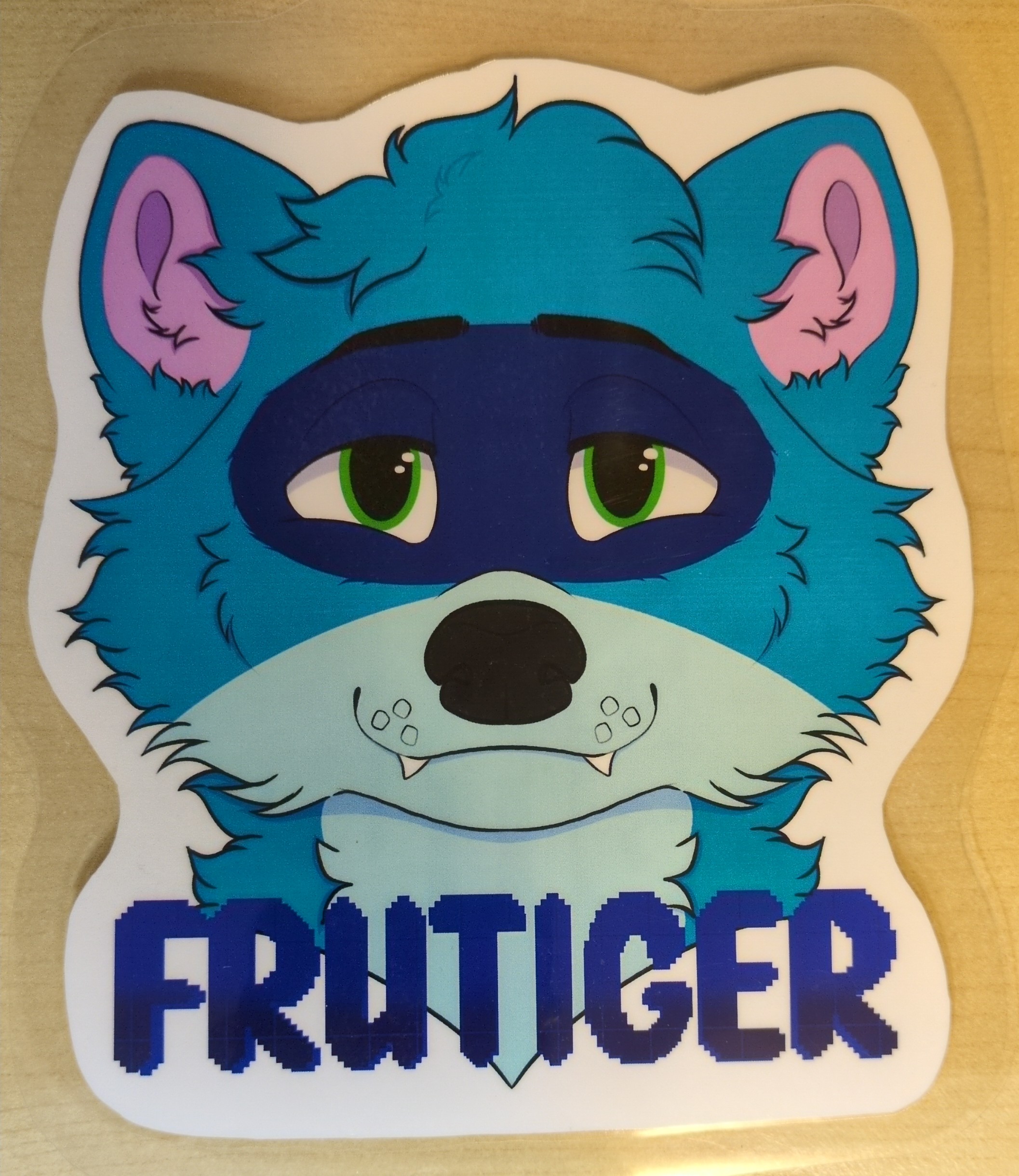 Picture of a laminated, printed art piece of a blue raccoon headshot.